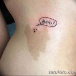 Фото небольшой татуировки на боку с изображением облачка и надписью 'Boo!'. Изображение выполнено в простом, мультяшном стиле.