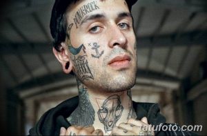 Фото тату на лице мужчины: олдскул, якорь, птица, надпись 'PUNK ROCK', традиционный стиль, яркие цвета, мастер тату, идеи для тату.