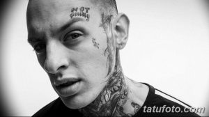 Фото тату на лице мужчины: надпись 'Not Guilty', символ доллара и татуировки на шее. Экстремальный и вызывающий стиль.