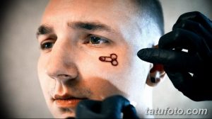 Фото тату на лице мужчины: небольшой рисунок пениса под глазом. Экстремальный и вызывающий стиль.