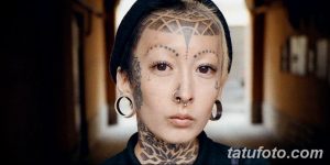 Фото тату: этническая татуировка на лице женщины, с геометрическими узорами на лбу и вокруг глаз. Традиционный и выразительный дизайн.