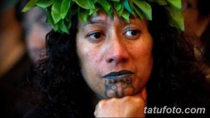 Фото тату на лице мужчины: традиционная татуировка маори с сложными узорами и спиралями, выполненная в черном цвете.