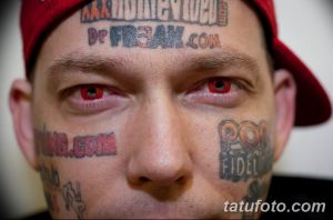 Фото мужчины с татуировкой на лбу и красными контактными линзами. Вызывающий и необычный образ, привлекающий внимание.