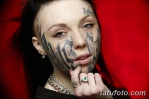 Фото тату: лицо девушки, покрытое яркими татуировками в стиле комиксов, с использованием черного, серого и белого цветов. Экстремальный рисунок татуировки.
