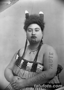 Фотография женщины с традиционными татуировками маори на лице и руке. Демонстрация древнего искусства и культурного наследия.