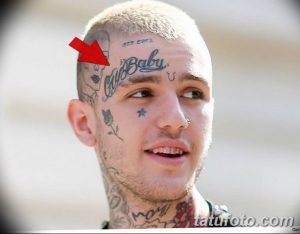 Фотография Lil Peep с многочисленными татуировками на лице, шее и голове. Видны надписи, звезды и другие символы.