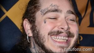 Фотография Post Malone с татуировками на лице, включая надпись 'Stay Away' на лбу и изображение птицы под глазом. Видны его борода и золотые зубы.