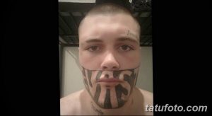 Фото тату: крупная надпись "NAS" на лице мужчины, выполненная черными чернилами. Необычный и вызывающий эскиз тату.