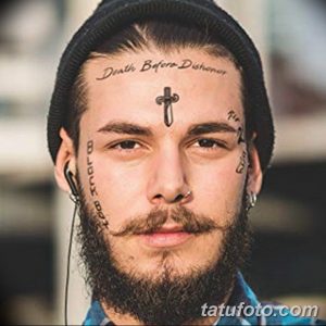 Фото тату: мужчина с татуировками на лице, включая надпись 'Death Before Dishonor', крест и надписи на щеках.