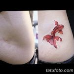 Фото тату: небольшая, реалистичная татуировка золотой рыбки на боку, выполненная в ярких цветах. Детализированный рисунок татуировки.