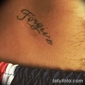 Фото татуировки на руке: изящная надпись "Forgiere" выполненная каллиграфическим шрифтом черными чернилами.