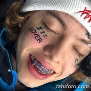 Фото тату 'ZZZ LOVER' под глазом молодого человека. Черный текст в стиле граффити, дерзкий и провокационный дизайн, портретное фото.