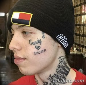 Фото татуировок на лице Лил Зена: надпись 'Candy Soldier' и флаг. Минималистичный стиль и провокационный выбор места.
