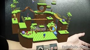 Фото тату с изображением игрового уровня Sonic the Hedgehog, включая персонажа, кольца и элементы окружения.