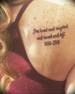 Фото тату на плече: надпись "She lived and laughed, and loved and left. 1936-2016" в красивом каллиграфическом стиле, посвященная памяти близкого человека.
