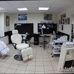 Фото современной тату-студии с белыми стенами, удобным креслом для клиента и профессиональным оборудованием. Акцент на гигиене и стерильности.