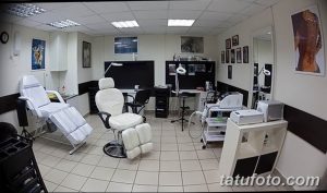 Фото современной тату-студии с белыми стенами, удобным креслом для клиента и профессиональным оборудованием. Акцент на гигиене и стерильности.