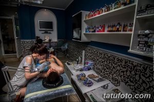 Фото процесса татуирования: мастер делает тату клиенту, сосредоточенный взгляд, профессиональное оборудование. Атмосфера творчества и доверия.