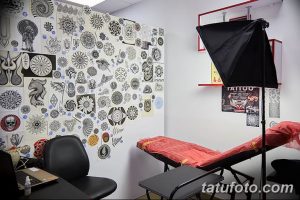 Фото стены, увешанной эскизами татуировок различных стилей и размеров. Большой выбор рисунков для вдохновения и выбора.