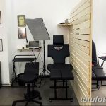 Фото интерьера тату-студии с удобными креслами, рабочими местами и стерильным оборудованием. Стены украшены эскизами татуировок.