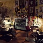 Фото интерьера тату-салона в темных тонах с религиозными изображениями на стенах, создающее атмосферу мистики и таинственности.