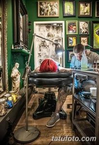 Фото процесса нанесения татуировки. Мастер в голубых перчатках работает над татуировкой на спине клиента.