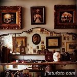 Фото интерьера тату-салона в винтажном стиле с черепами в рамах, портретами и тату-оборудованием. Атмосфера таинственности и творчества.