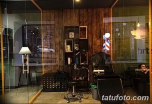Фото уютной тату-студии с деревянной отделкой, приглушенным освещением и стильным креслом для татуировки.