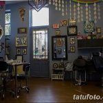 Фото тату-студии с ярким интерьером, множеством эскизов на стенах, удобными креслами для клиентов и рабочим местом мастера.