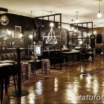 Фото креативной тату-студии с граффити на стенах, необычной мебелью и ярким освещением. Идеальное место для тех, кто ищет оригинальные татуировки.
