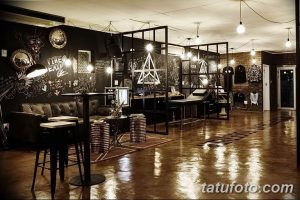 Фото креативной тату-студии с граффити на стенах, необычной мебелью и ярким освещением. Идеальное место для тех, кто ищет оригинальные татуировки.