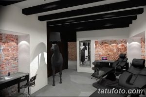 Фото элегантной тату-студии с кирпичными стенами, черными элементами декора и удобными креслами. Идеальное место для тех, кто ценит стиль и качество.
