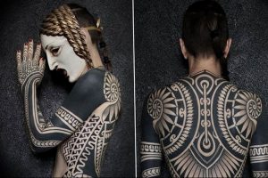 Фото тату: черно-белая татуировка в стиле Blackwork, покрывающая спину, руки и плечи женщины сложными геометрическими узорами и орнаментами.