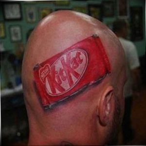 Фото 3D татуировки в виде шоколадного батончика KitKat на голове мужчины. Уникальный и реалистичный рисунок.