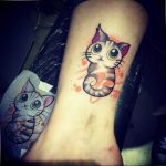 Фото тату милого котенка с большими зелеными глазами, выполненного в ярких цветах на руке девушки. Идеальный эскиз тату для кошатников.