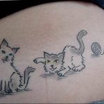 Милая татуировка на боку, изображающая двух котят, играющих с клубком ниток. Черно-белый рисунок с небольшими цветными акцентами.
