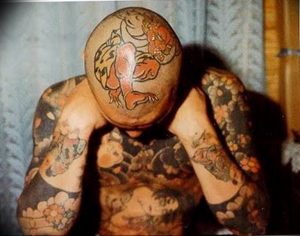 Фото мужчины с татуировкой тигра на голове и теле, выполненной в традиционном японском стиле.