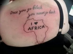 Фотография татуировки на спине с надписью 'Once you go black you never go back' и контуром Африки с надписью 'I ❤️ AFRICA'.