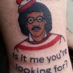 Фото тату на руке: изображение Уолдо из книг "Где Уолдо?" с надписью "Hello, is it me you're looking for?". Яркий и юмористический рисунок татуировки.