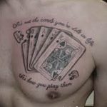 Фото тату на груди: черно-серый рисунок с игральными картами и надписью. Детализированный эскиз татуировки.