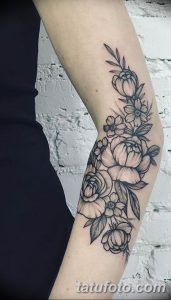 Фото тату: изящный цветочный узор, выполненный в технике line work, обвивает предплечье, создавая эффект рукава. Нежные бутоны и листья.