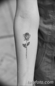 Фото тату: небольшая, изящная роза, выполненная в технике blackwork, расположена на предплечье.