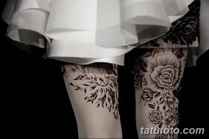 Фото тату: две женские ноги с татуировками в стиле blackwork. На одной ноге изображены ветви с листьями, на другой – пышные розы. Эскиз татуировки роз символизирует красоту и страсть.