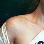 Фото белой татуировки с изображением роз на женском плече. Нежный и изящный рисунок, выполненный в технике white ink.