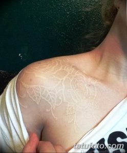 Фото белой татуировки с изображением роз на женском плече. Нежный и изящный рисунок, выполненный в технике white ink.