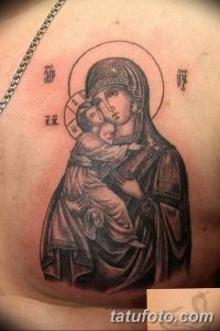 Фото тату Богоматери с младенцем Иисусом в черно-белом стиле на груди. Детализированное изображение лиц и головных уборов.