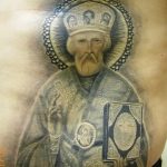 Фото тату Святителя Николая Чудотворца на груди. Черно-серый рисунок татуировки с детальной проработкой лица и облачения.