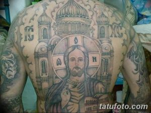 Фото масштабной татуировки Христа и храма на спине. Черно-серый рисунок татуировки с детальной проработкой архитектуры и лица Христа.