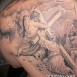 Фото татуировки Снятия с креста на лопатке, выполненной в черно-серых тонах. Изображение детально проработано и имеет драматичный вид.