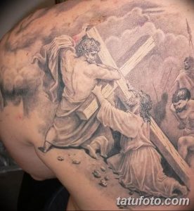 Фото татуировки Снятия с креста на лопатке, выполненной в черно-серых тонах. Изображение детально проработано и имеет драматичный вид.